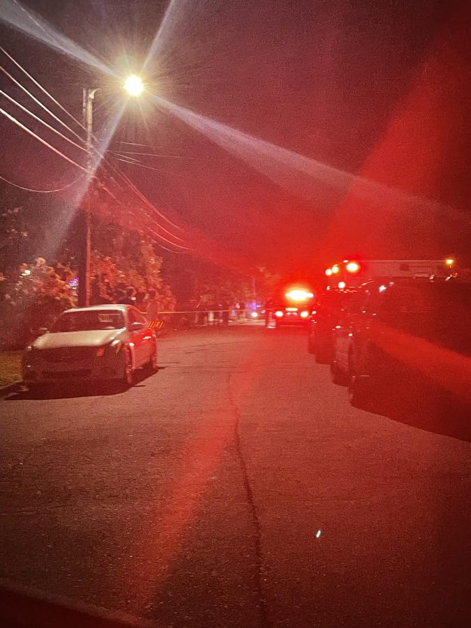 Scene outside party after students evacuated, ambulance lights.